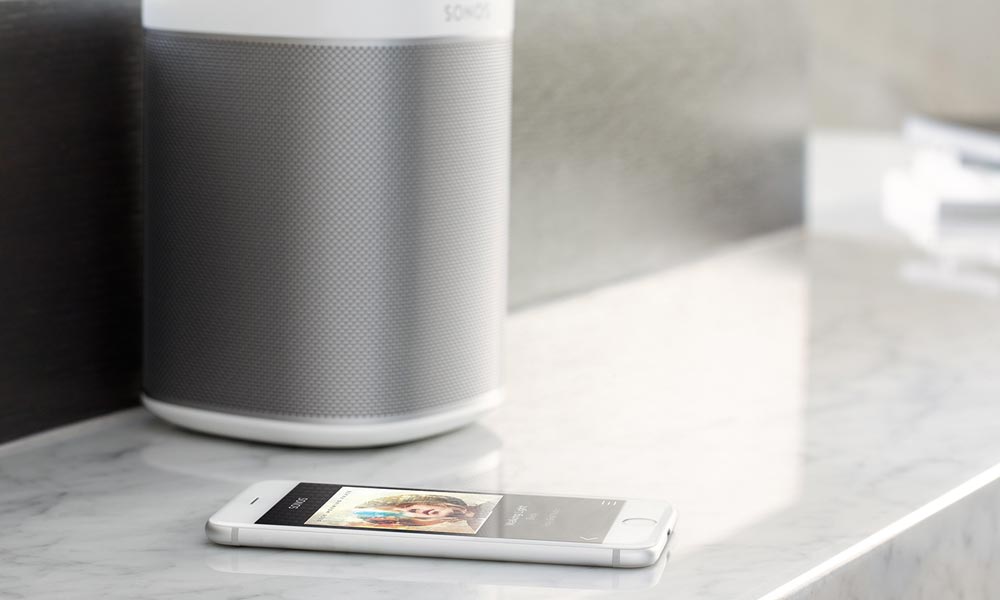 iphone on marble next to Sonos speaker